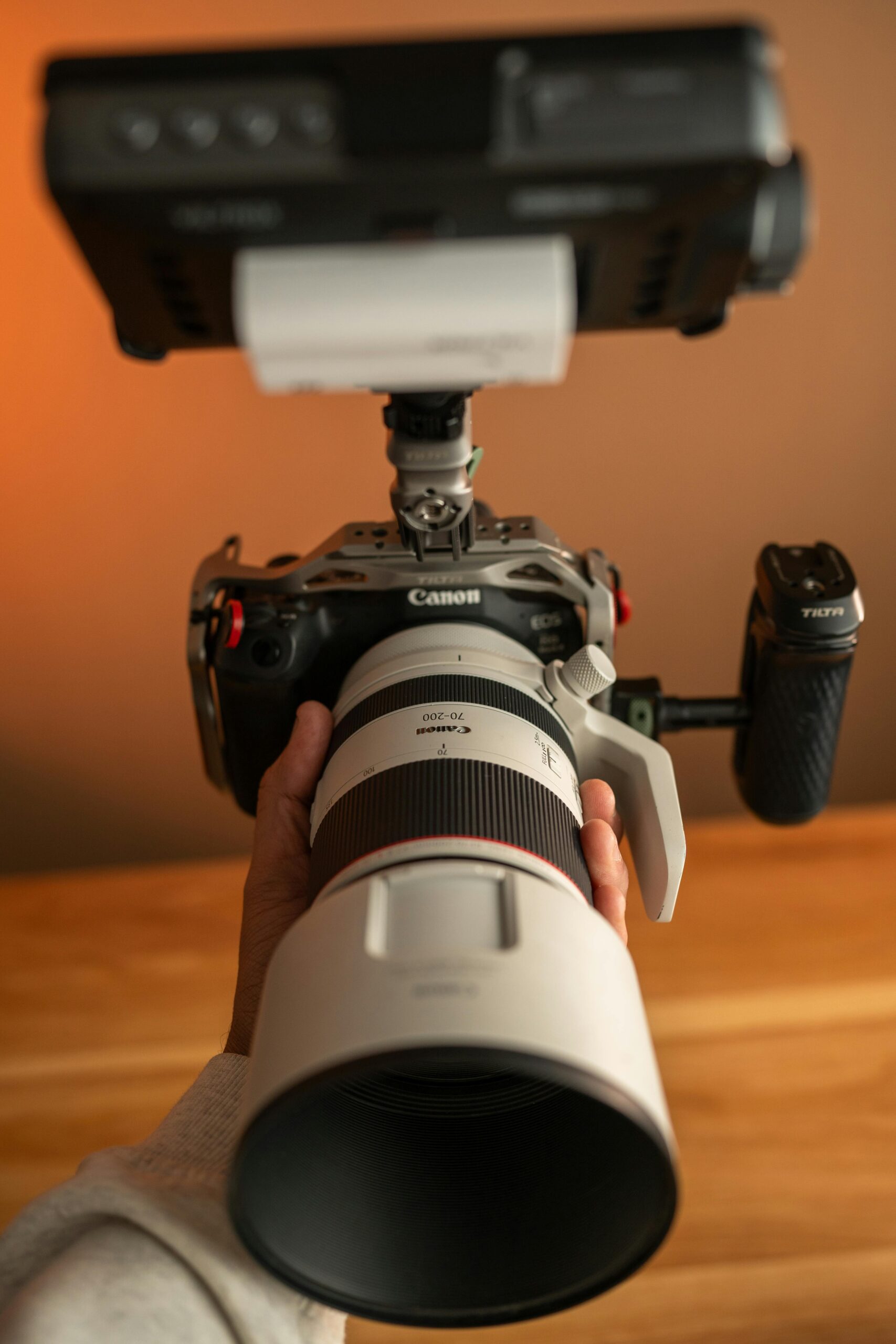 Detailed view of a professional camera setup featuring a telephoto lens and various attachments.
